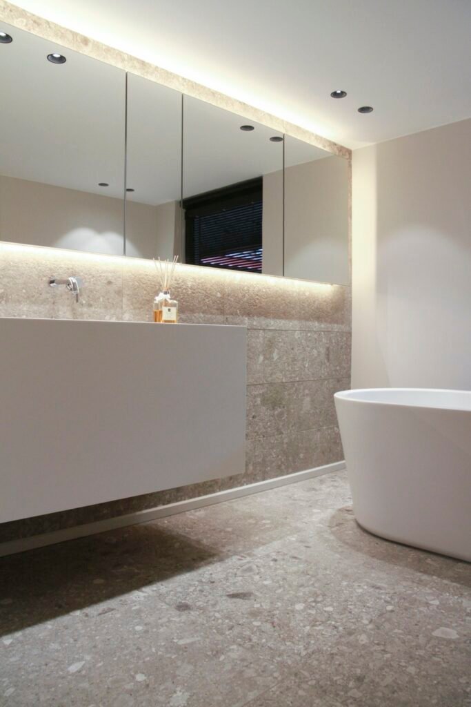 Backlit bathroom mirror glowing softly above a vanity