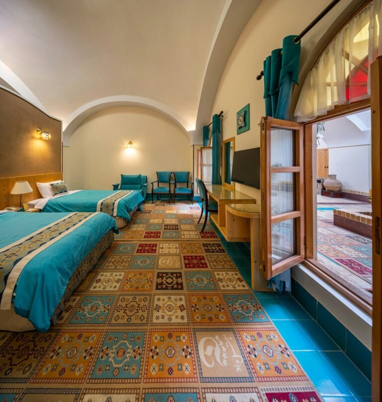 Boutique hotel room with layered lighting, upholstered headboard, and warm material palette