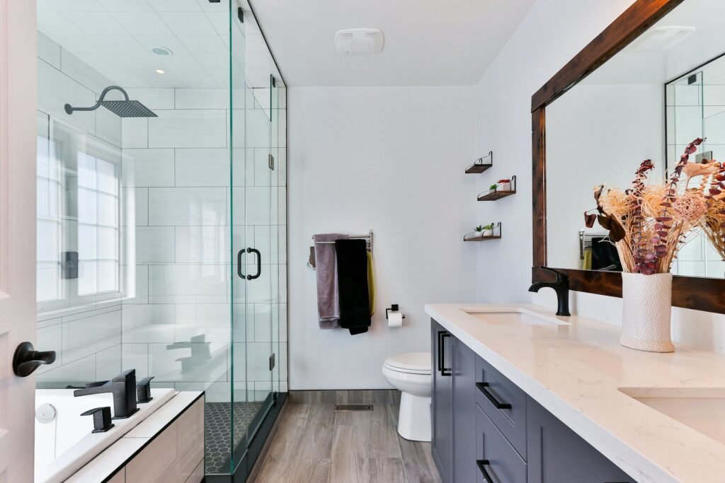 Small white-tiled New York apartment bathroom with a compact vanity and walk-in shower