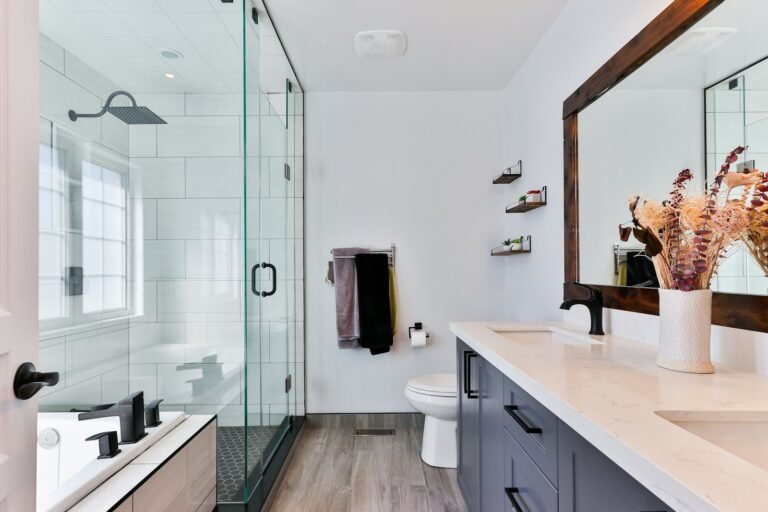 Small white-tiled New York apartment bathroom with a compact vanity and walk-in shower