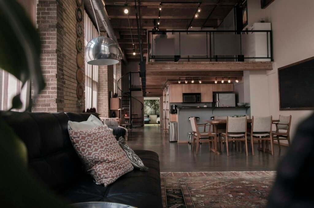 Converted Tribeca loft interior with exposed brick, steel columns, and large warehouse windows