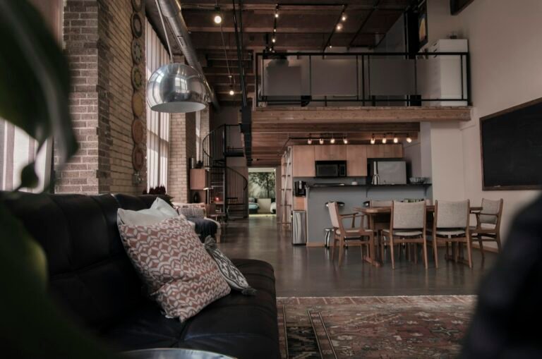 Converted Tribeca loft interior with exposed brick, steel columns, and large warehouse windows