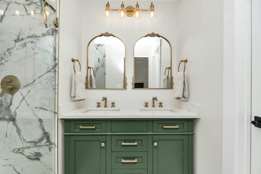 Bathroom vanity with mirror lit by wall sconces at eye level