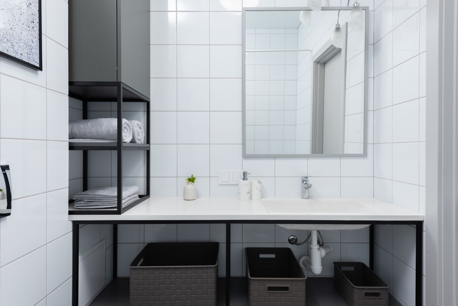 Modern bathroom with a slim counter, wall mirror and open shelving above the sink
